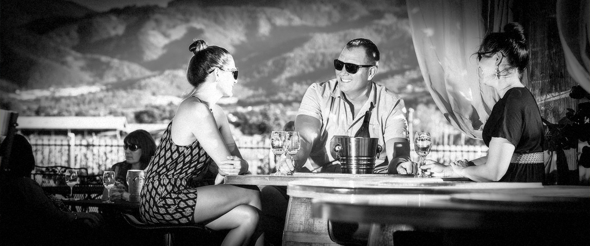 2Hawk Vineyard and Winery Friends Enjoying Wine-Tasting Against Stunning Mountain Backdrop (Grayscale)