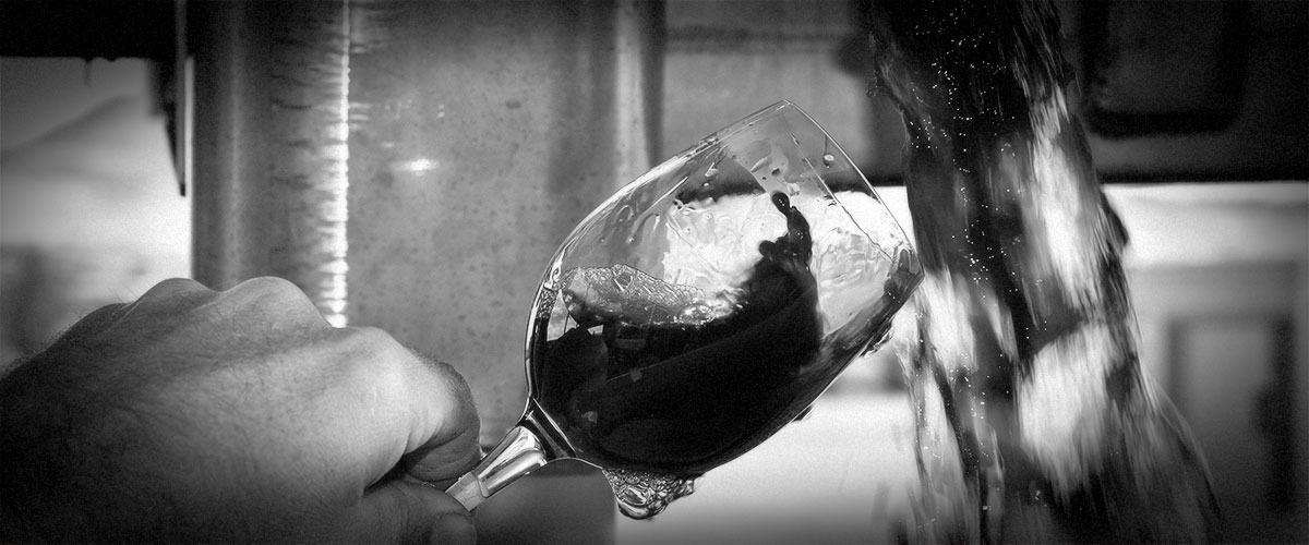 2Hawk Vineyard and Winery Winemaker Kiley Evans Testing Red Wine with Wine Glass (Grayscale)